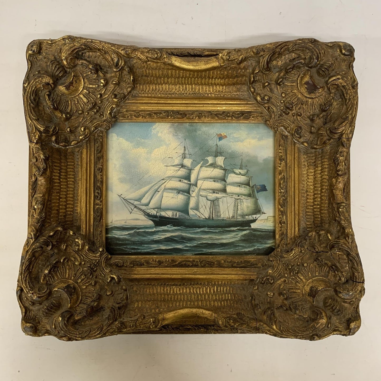 A VINTAGE PRINT ON BOARD OF A CLIPPER/SAILING SHIP IN FULL SAIL IN A HIGHLY ORNATE GILDED FRAME