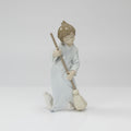 A collection of decorative items on a white studio background, including four small porcelain figurines and a large dark red crystal candle holder with hanging clear crystals.