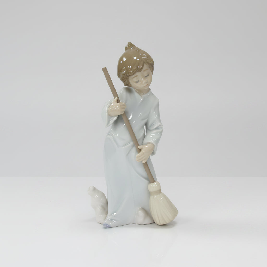A collection of decorative items on a white studio background, including four small porcelain figurines and a large dark red crystal candle holder with hanging clear crystals.