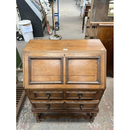 An early 20th century carved oak bureau - approx. 99cm high x 77cm wide x 45cm deep