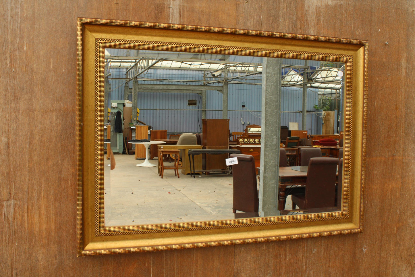 A VINTAGE GILT FRAMED BEVEL EDGE WALL MIRROR