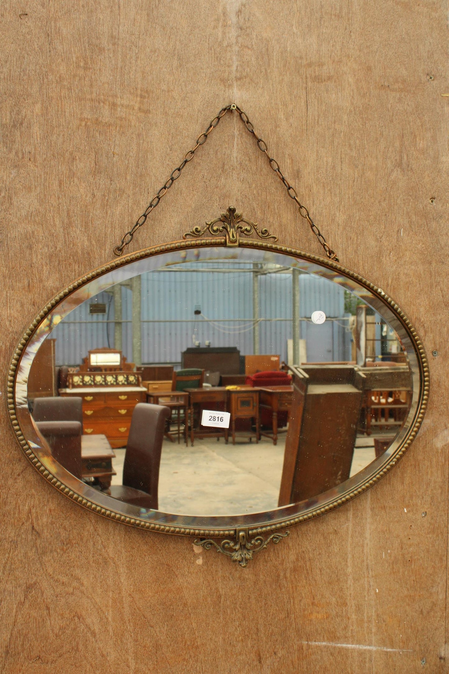 A MID 20TH CENTURY OVAL BEVEL EDGE WALL MIRROR