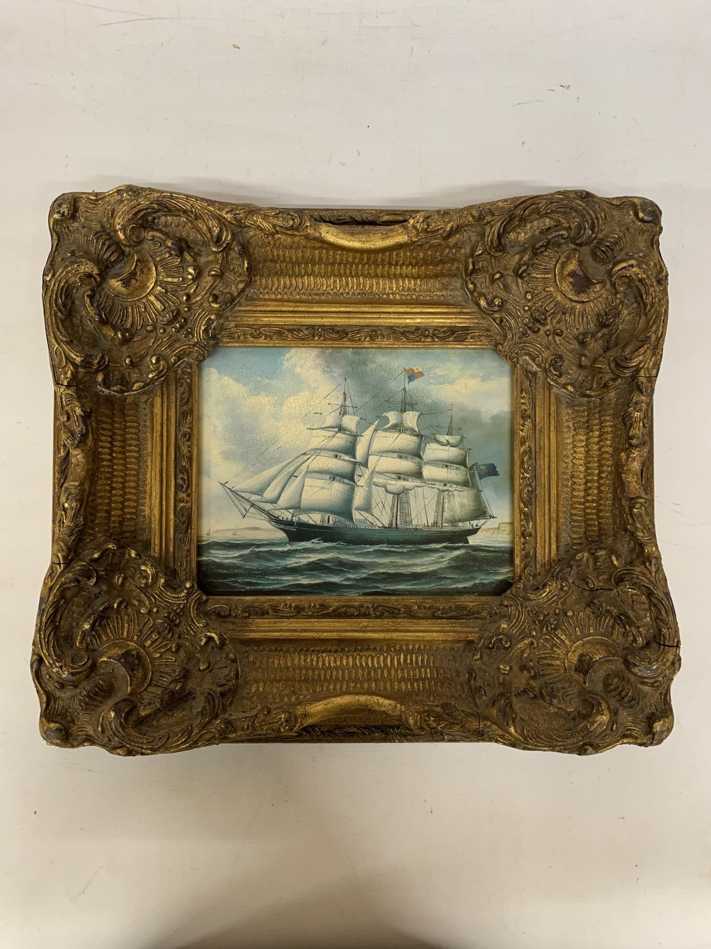 A VINTAGE PRINT ON BOARD OF A CLIPPER/SAILING SHIP IN FULL SAIL IN A HIGHLY ORNATE GILDED FRAME