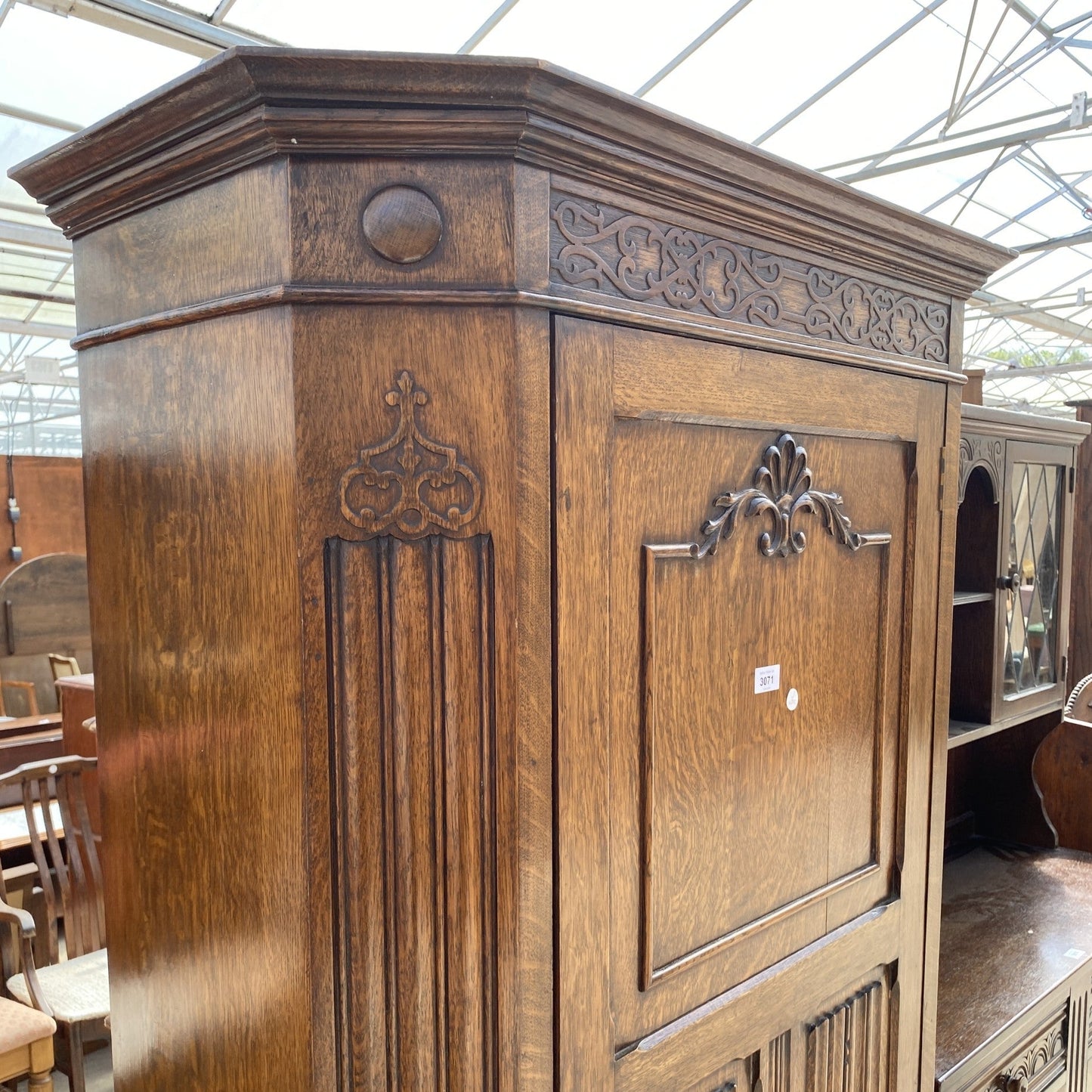 AN EARLY 20TH CENTURY OAK HALL WARDROBE WITH LINEN FOLD AND FOLIATE DECORATION 38" WIDE