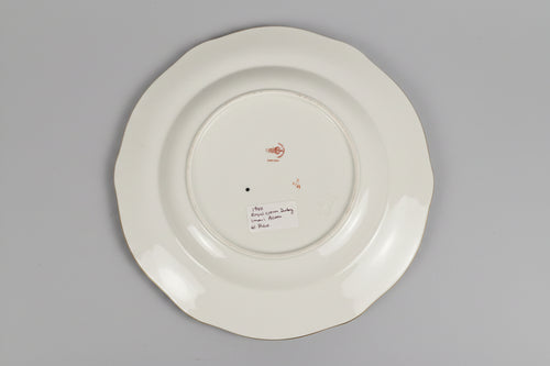 White plate with gold rim on a lace tablecloth