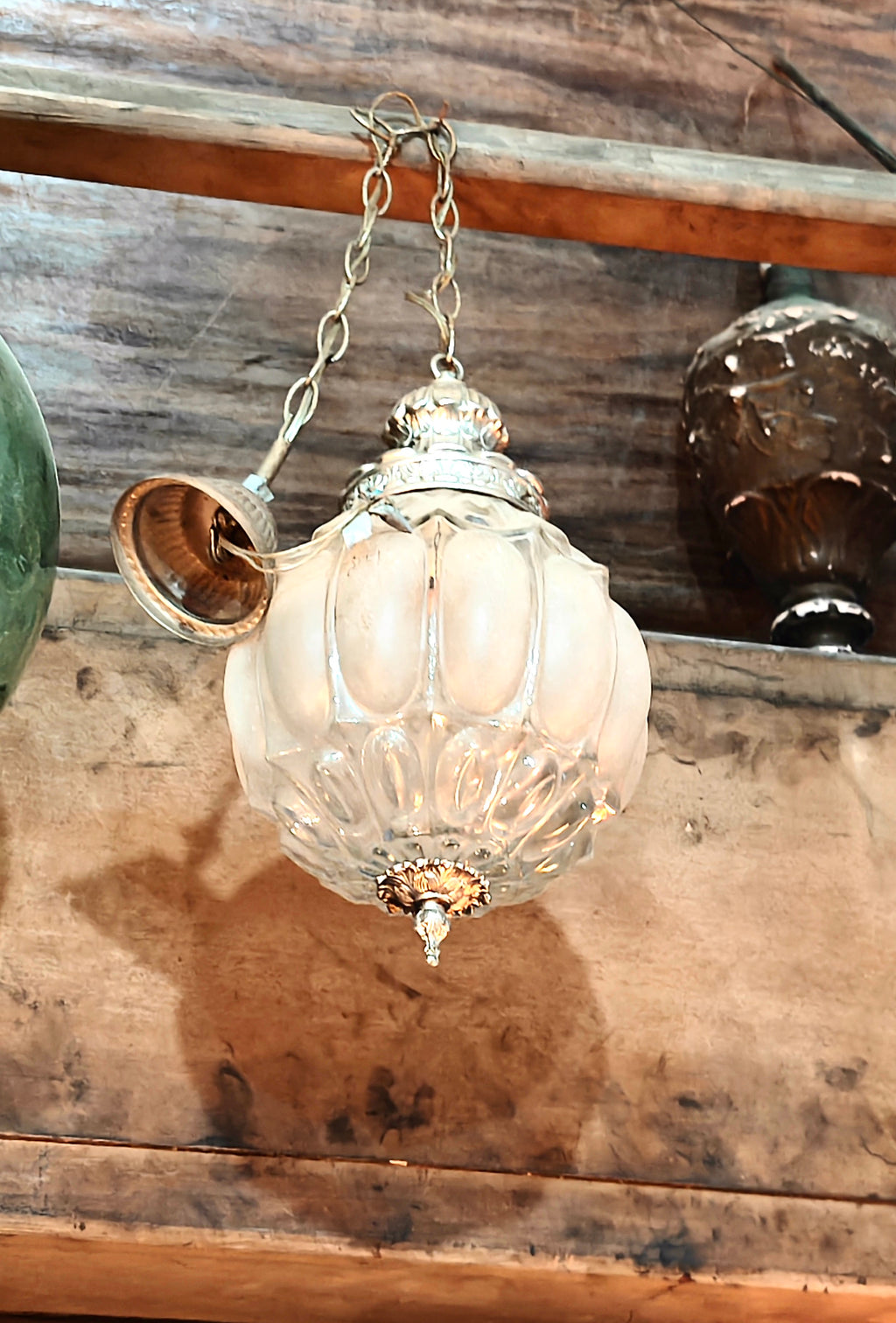Vintage-style glass hanging light fixture on a wooden surface