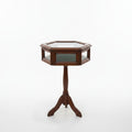 A hexagonal wooden display table with a glass top and three legs, photographed against a plain wall and light wood floor.