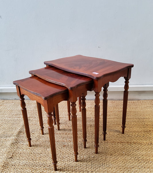A nest of three inlaid mahogany occasional tables