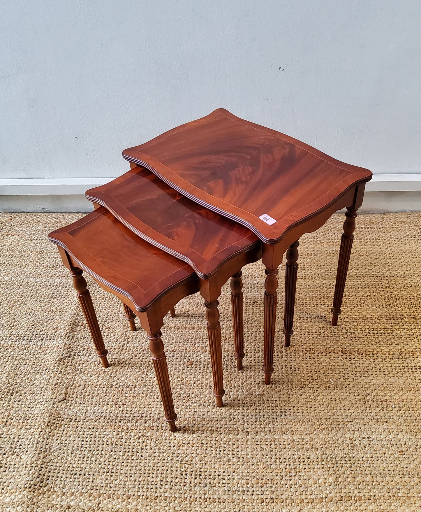A nest of three inlaid mahogany occasional tables