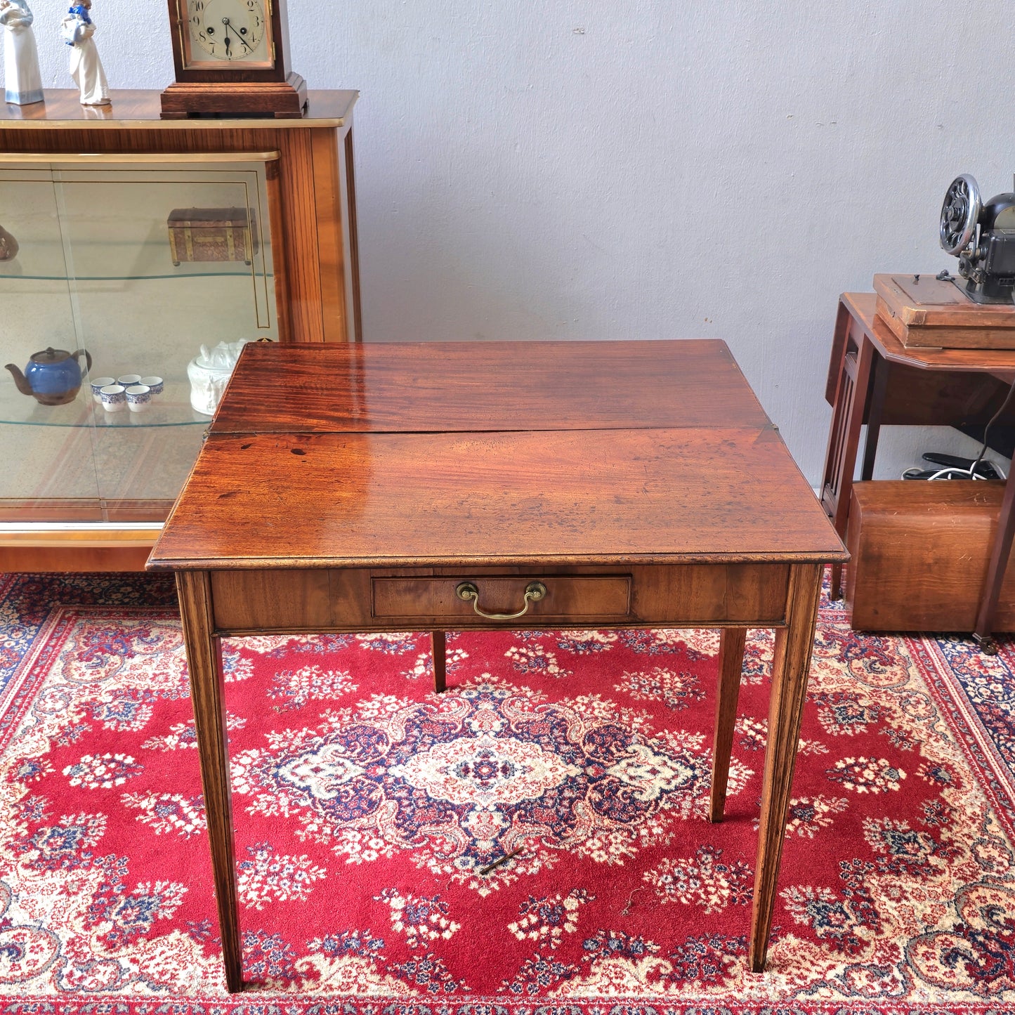 19th Century mahogany fold over tea table, fitted with a small drawer
