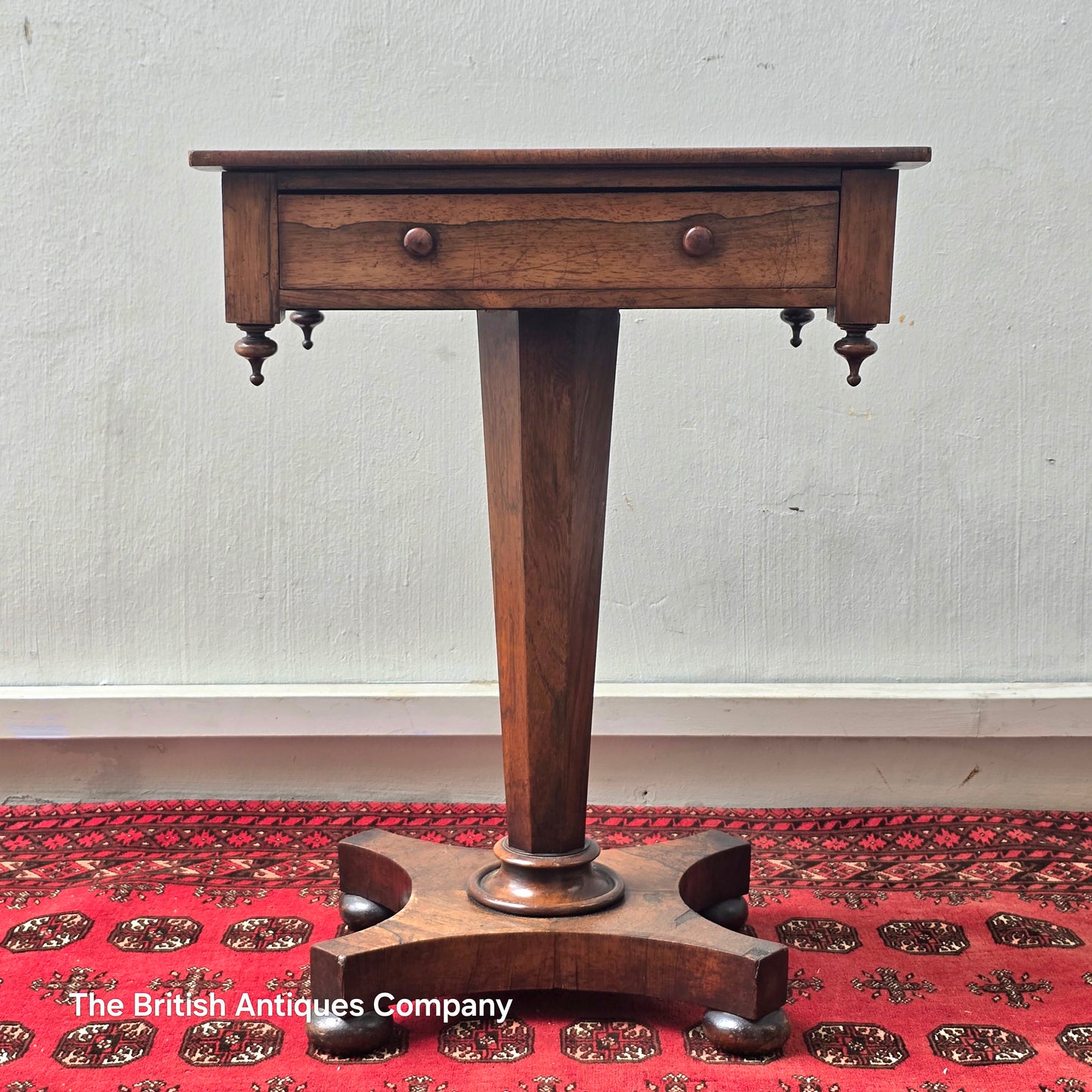 A VICTORIAN ROSEWOOD PEDESTAL CENTRE TABLE WITH SINGLE DRAWER ON BUN FEET, 21.5" X 17"