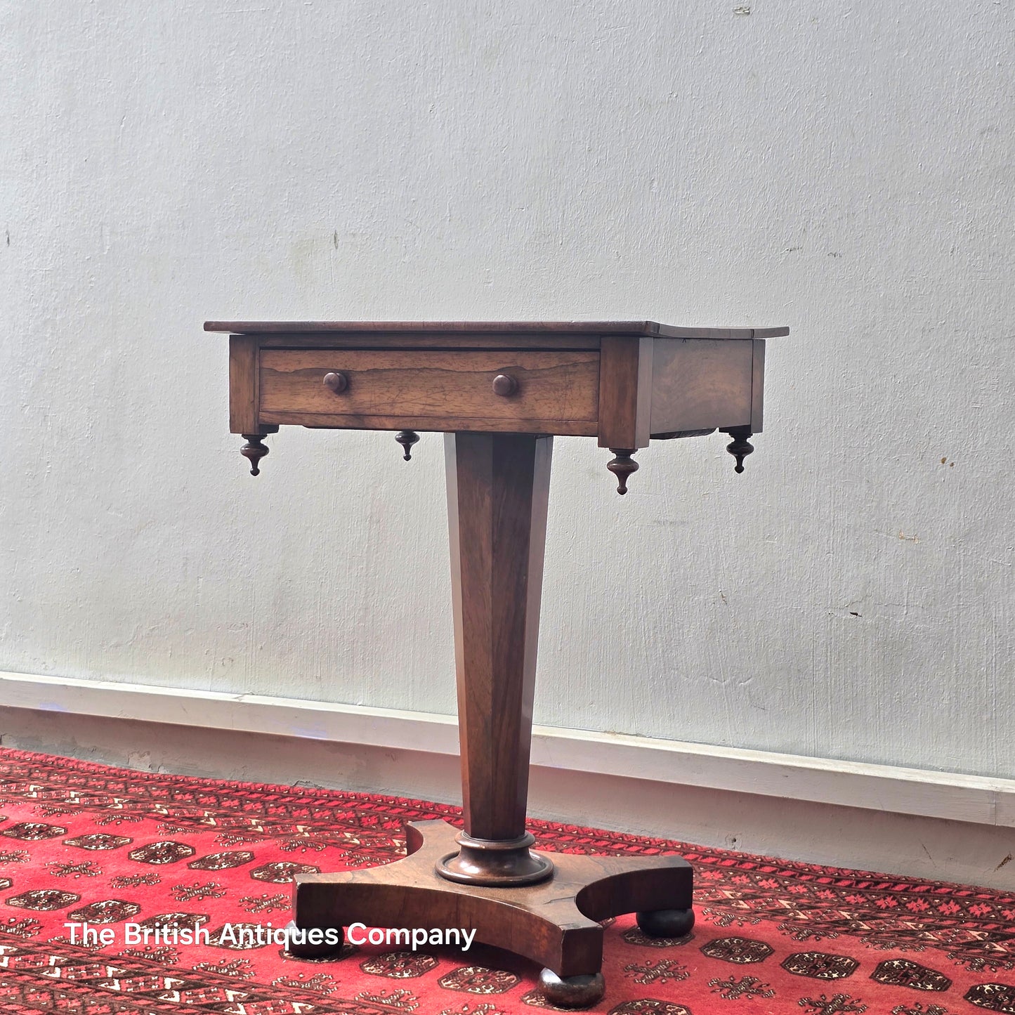 A VICTORIAN ROSEWOOD PEDESTAL CENTRE TABLE WITH SINGLE DRAWER ON BUN FEET, 21.5" X 17"