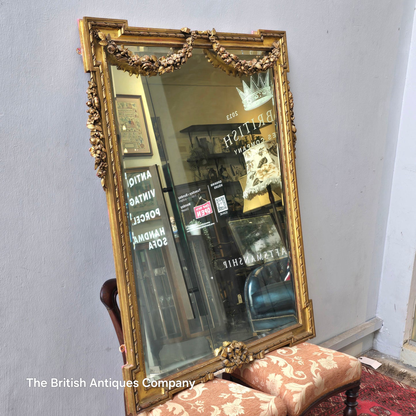 A 19TH CENTURY GILT WALL MIRROR WITH BEVEL EDGE AND DECORATED WITH SWAGS, 47" X 38"
