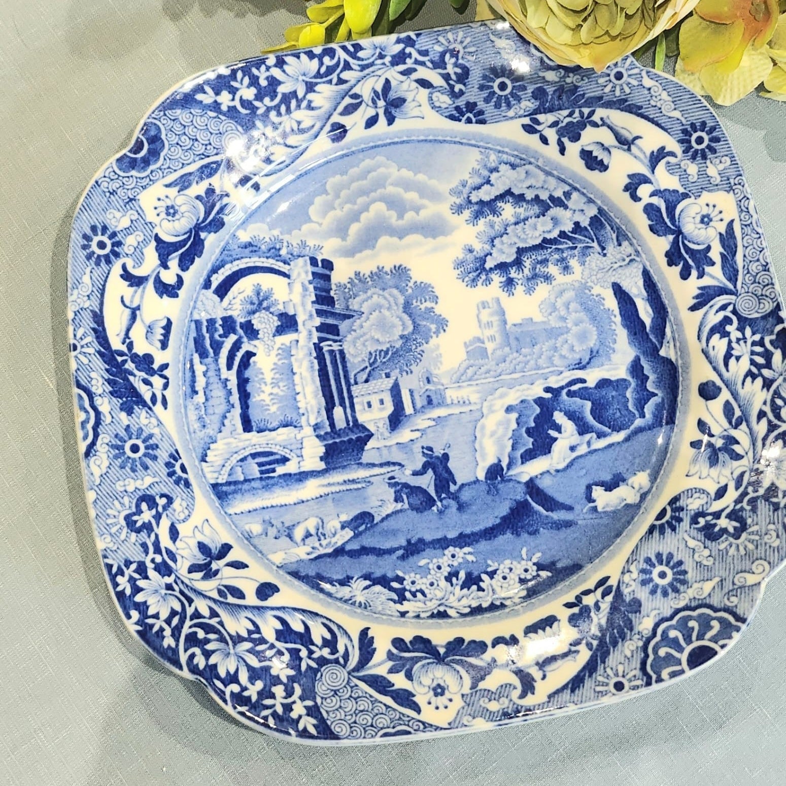 A blue and white floral patterned Spode porcelain plate with a classical architectural border.