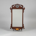 Decorative wooden mirror with intricate carvings on a gray background