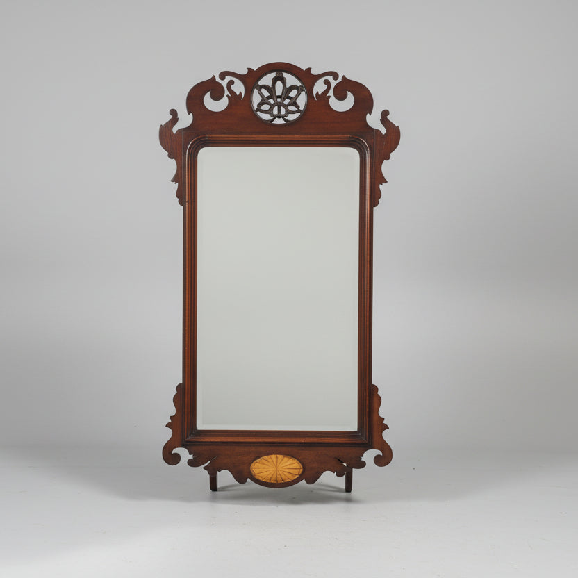 Decorative wooden mirror with intricate carvings on a gray background