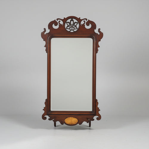 Decorative wooden mirror with intricate carvings on a gray background
