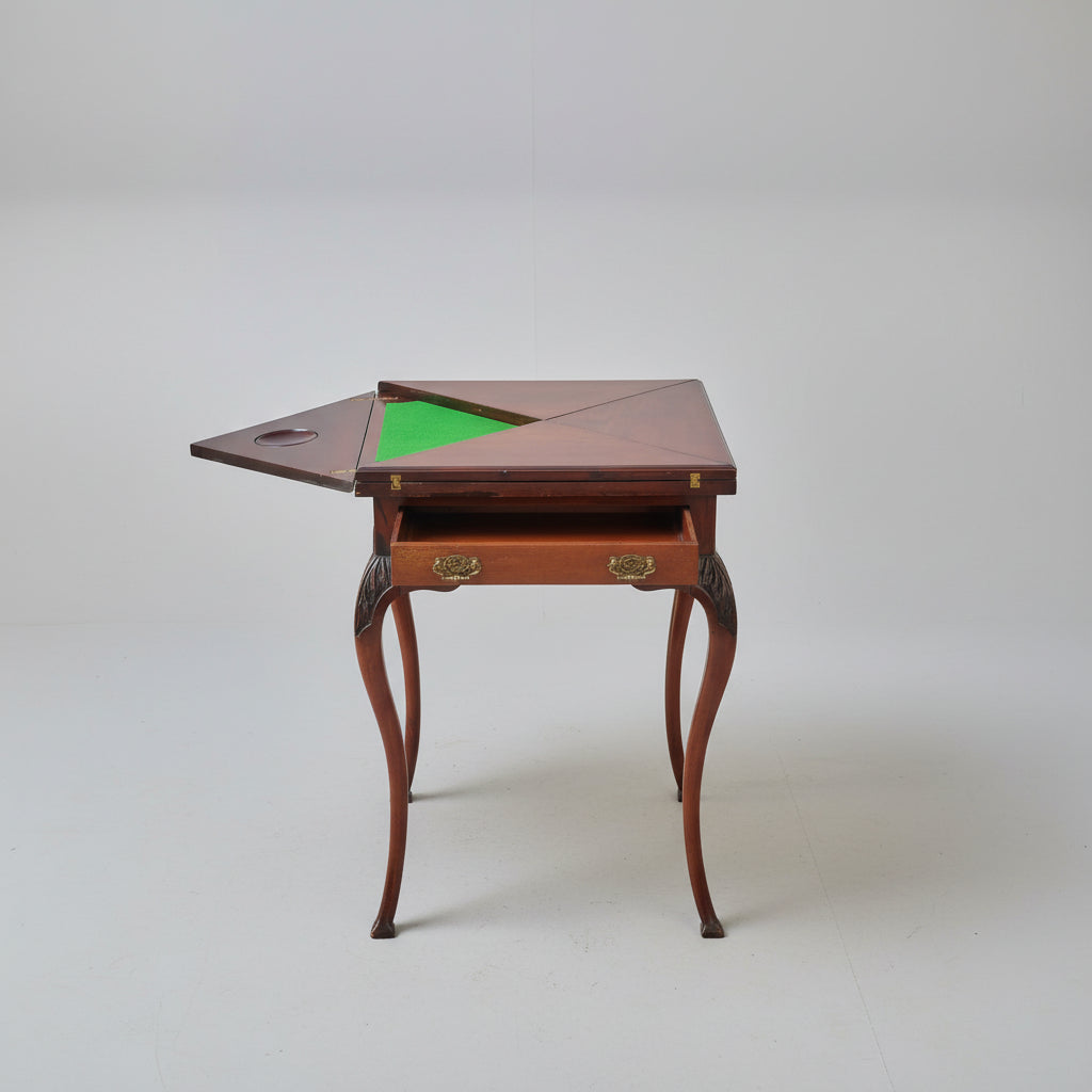 Wooden gaming table with green felt surface on a red patterned rug