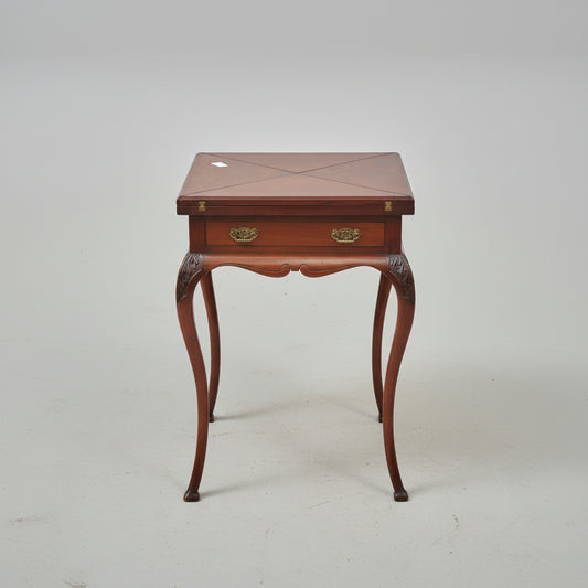 Wooden side table on a red patterned rug with decorative elements.