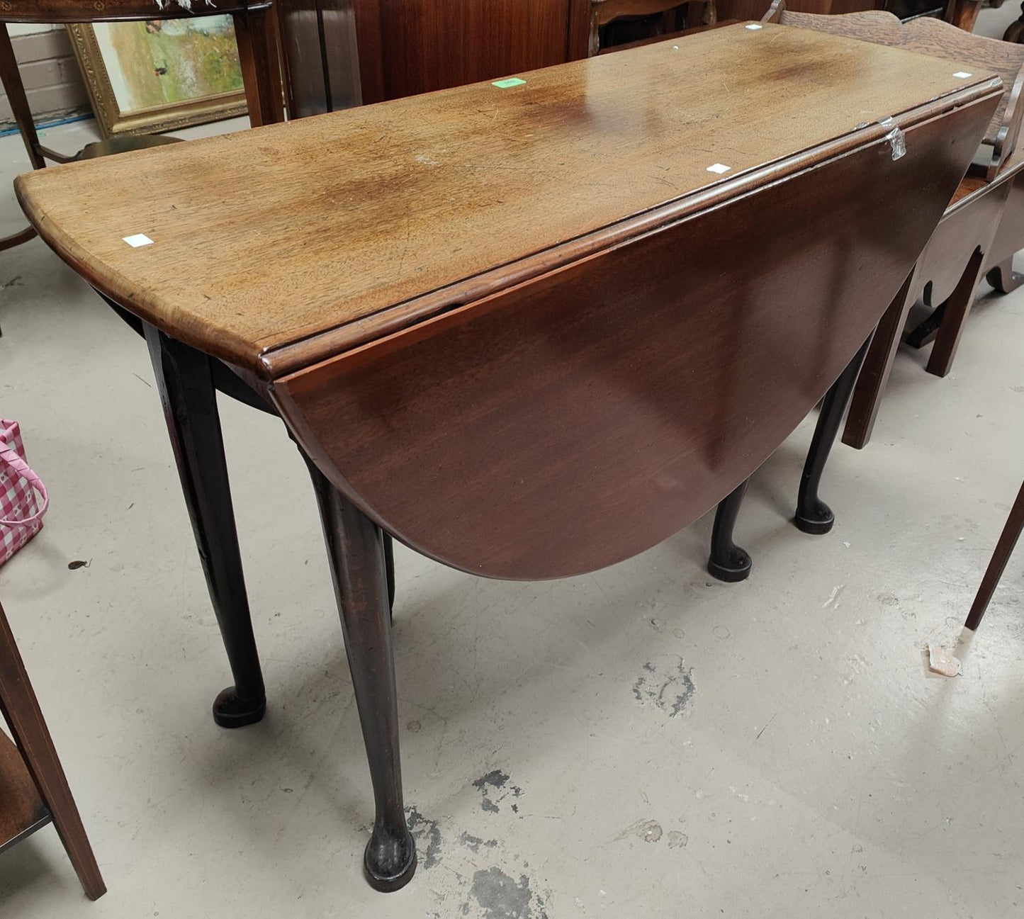 A mid 18th century mahogany dining table with oval drop leaf top