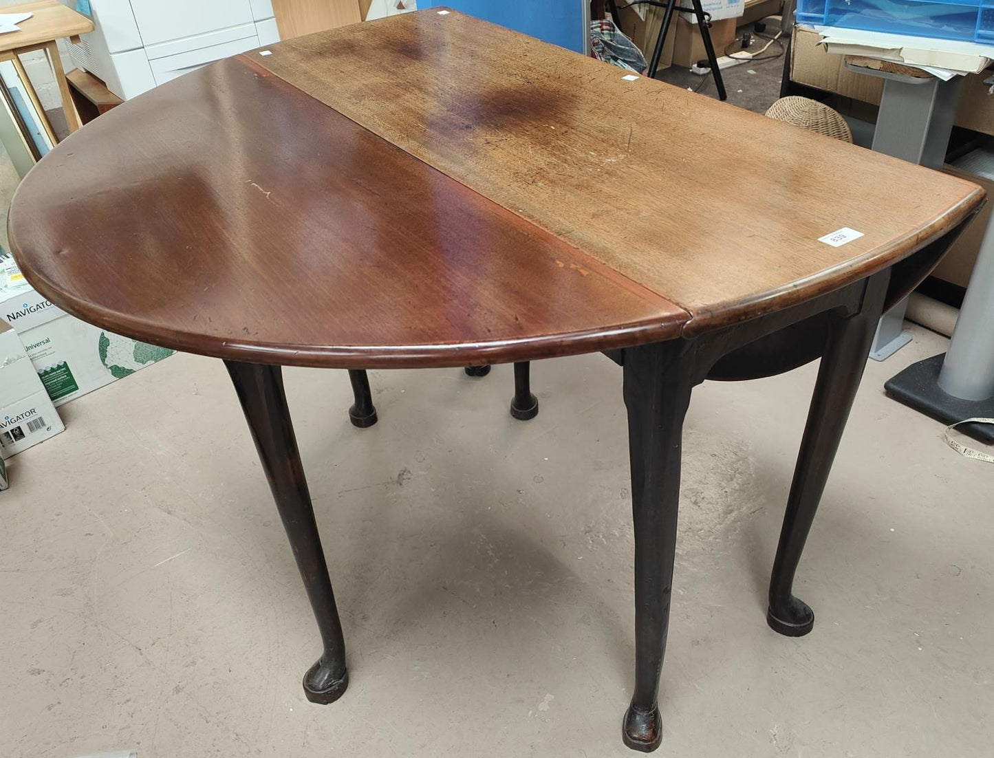 A mid 18th century mahogany dining table with oval drop leaf top