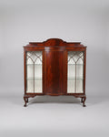 Wooden display cabinet with glass doors in a room setting