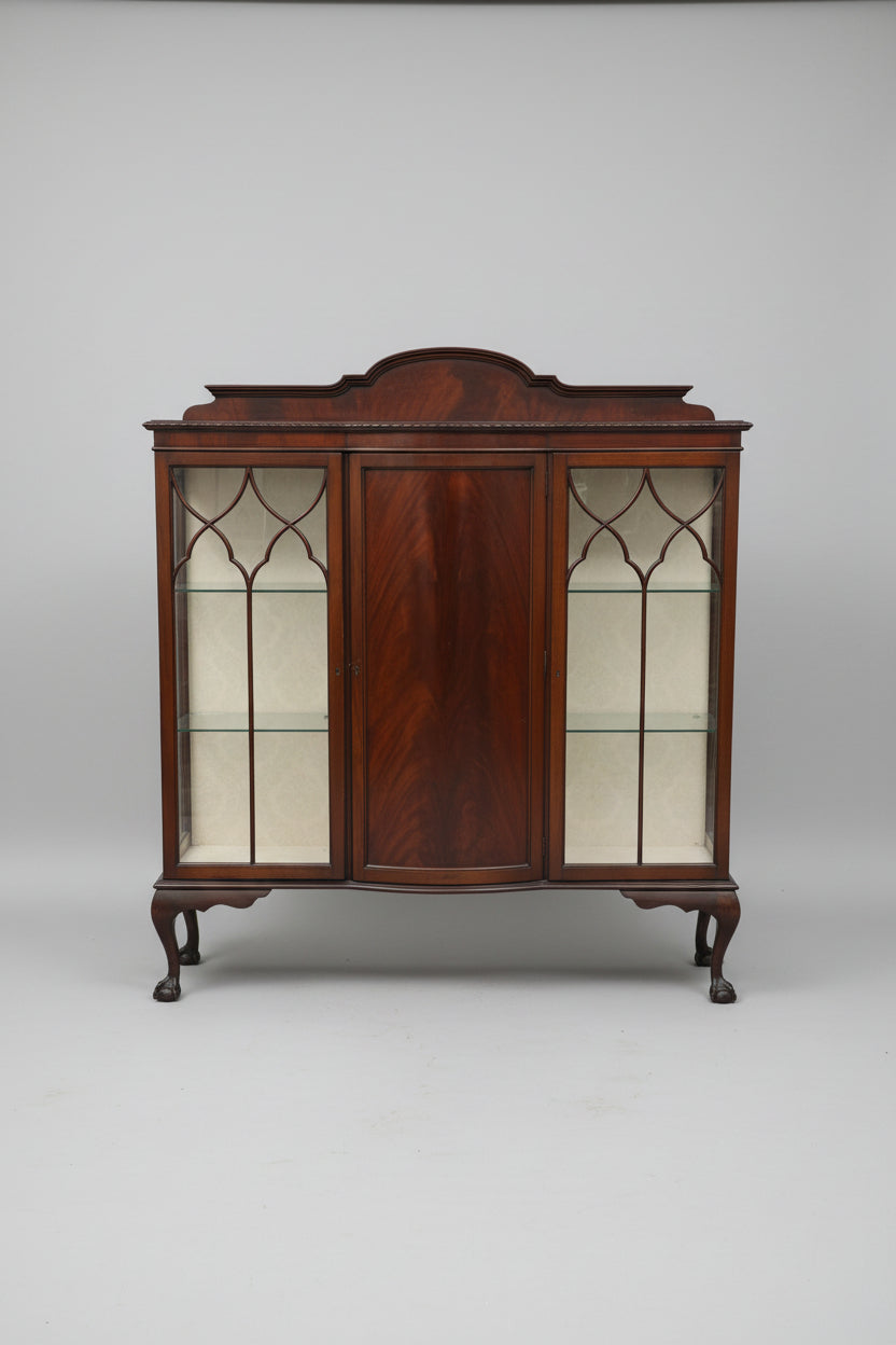 Wooden display cabinet with glass doors in an indoor setting