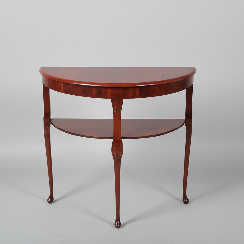 Wooden half-moon table with two shelves on a gray background