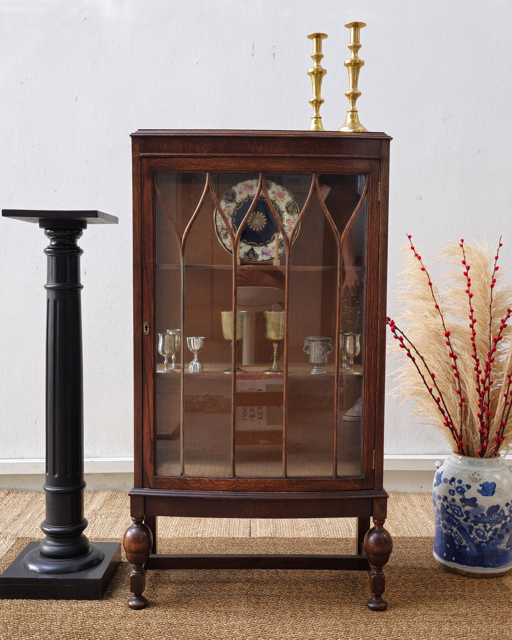 Wooden display cabinet with glass doors on a white wall background