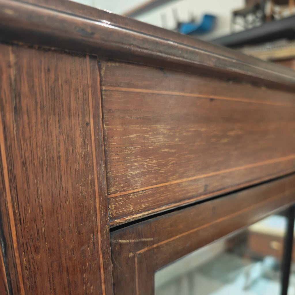 Close-up of a wooden frame with glass, showing wear and tear.
