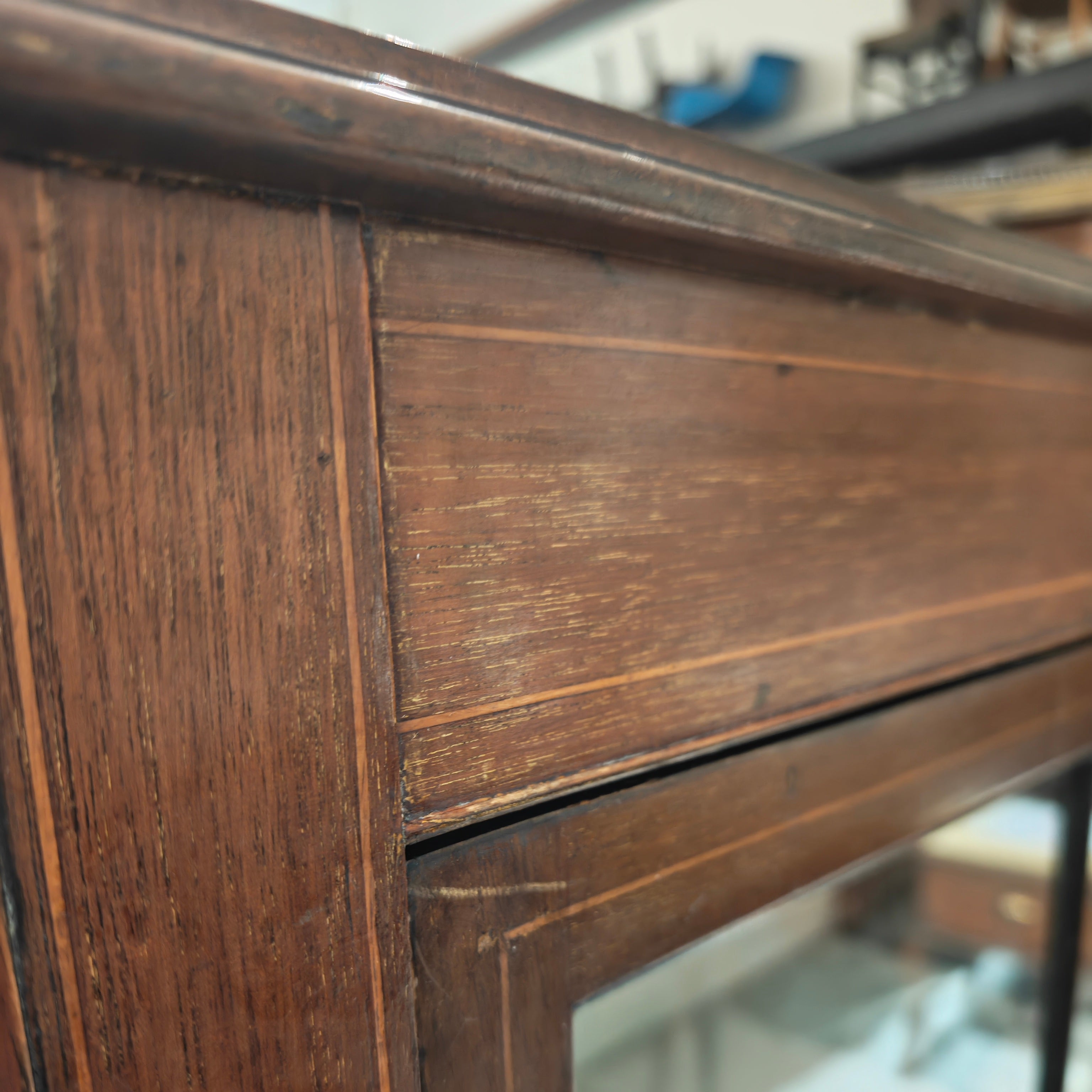 Close-up of a wooden frame with glass, showing wear and tear.
