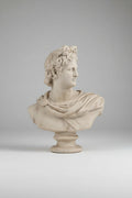 A classical-style stone bust sculpture of a man in profile wearing a laurel wreath and draped fabric, mounted on a pedestal base.