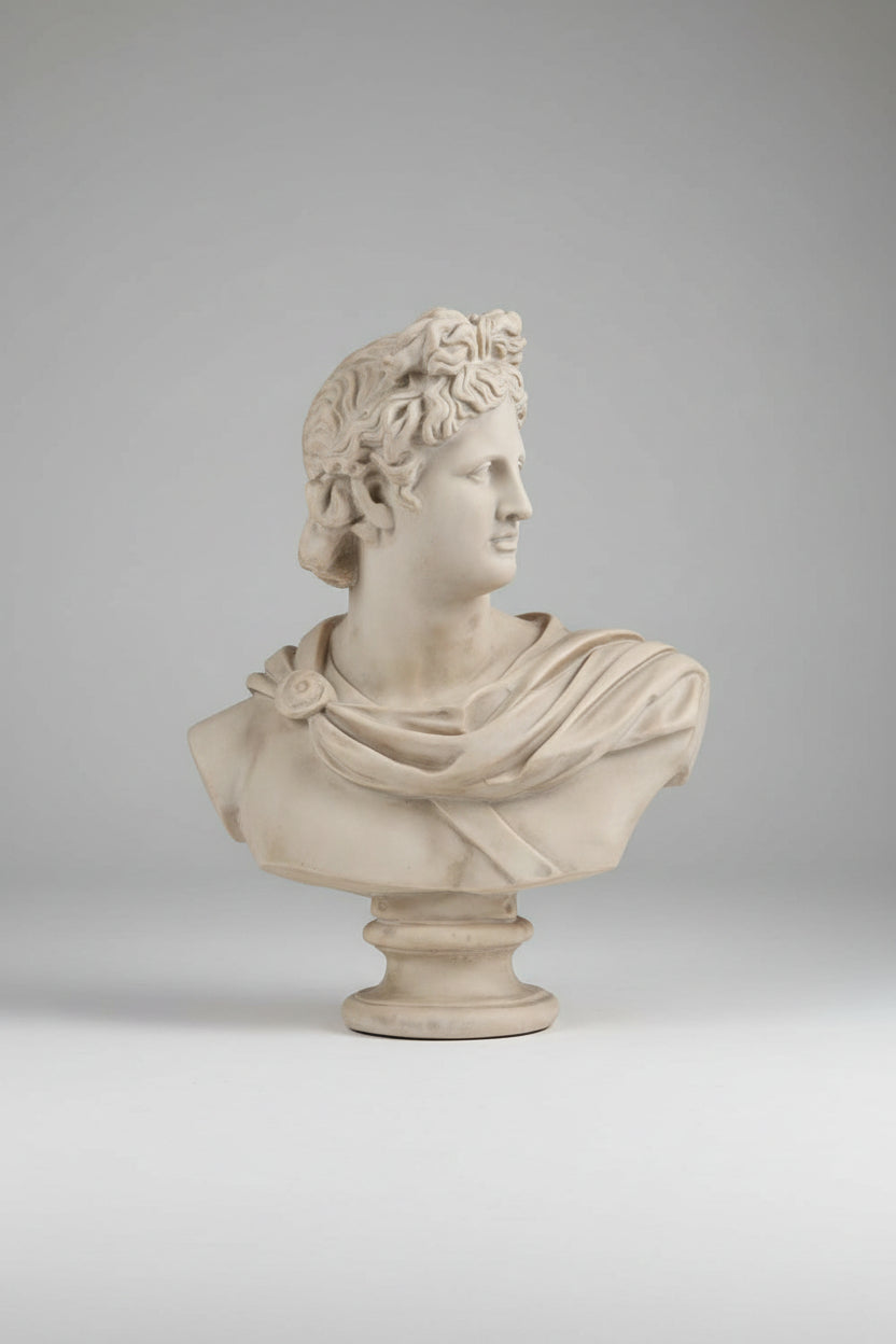 A classical-style stone bust sculpture of a man in profile wearing a laurel wreath and draped fabric, mounted on a pedestal base.
