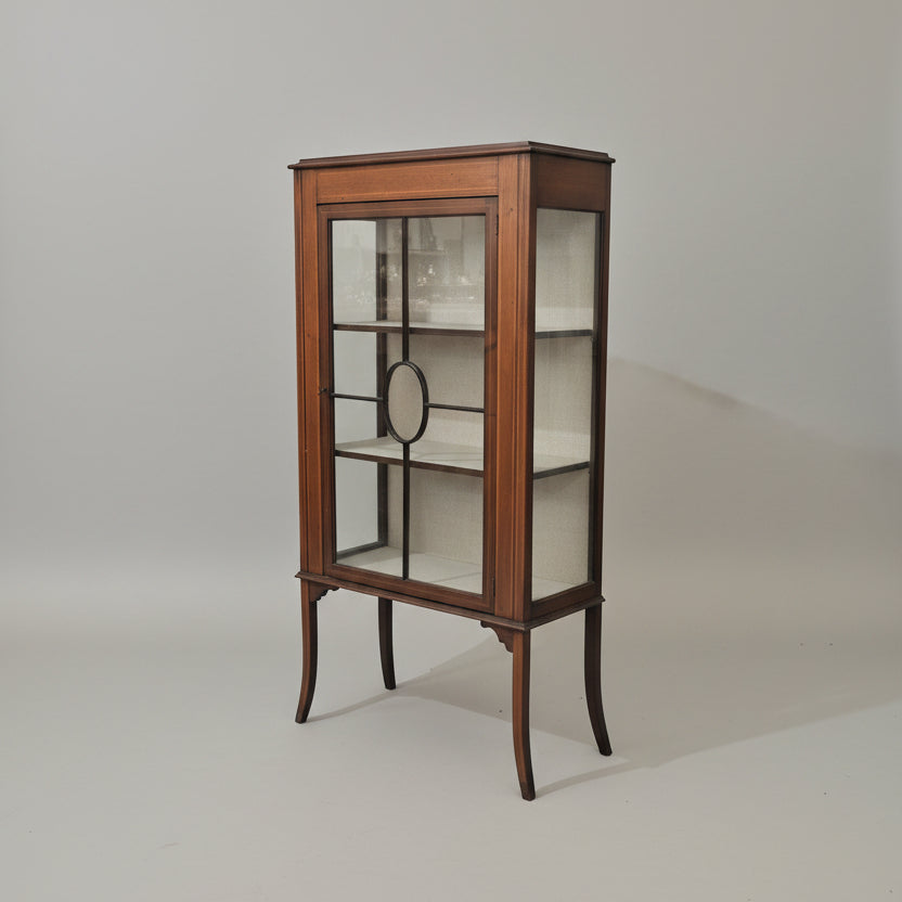 Wooden display cabinet with glass doors on a plain background