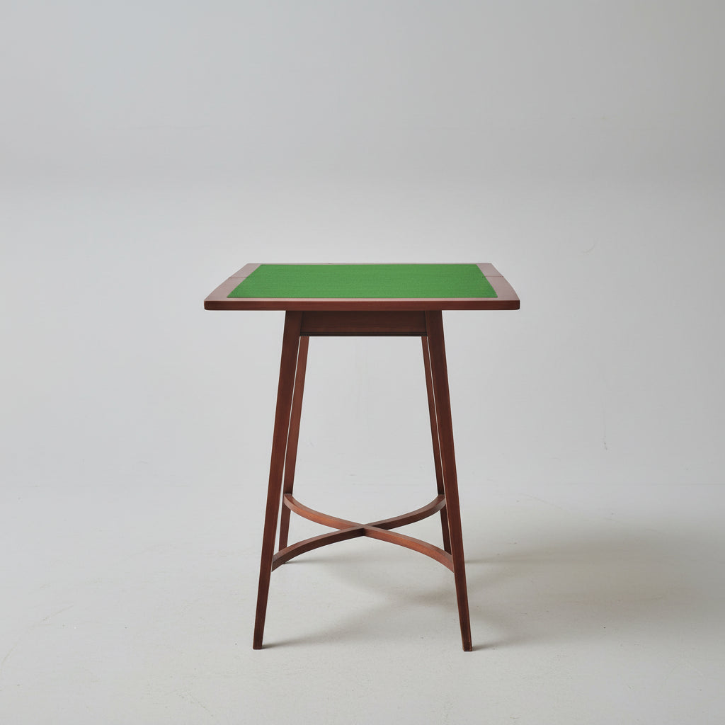 Wooden table with green surface and decorative items on a red patterned rug