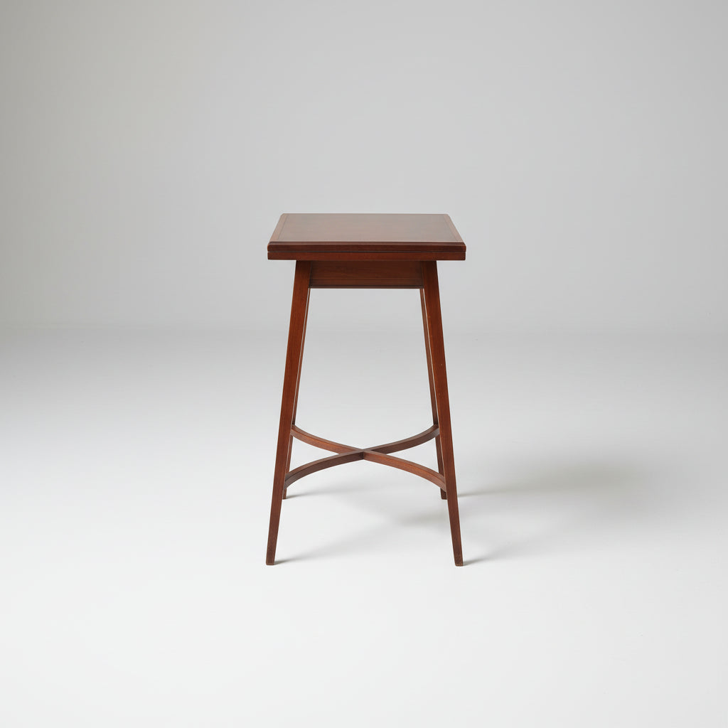 Wooden table on a red patterned rug with a wooden cabinet in the background
