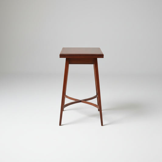 Wooden table on a red patterned rug with a wooden cabinet in the background
