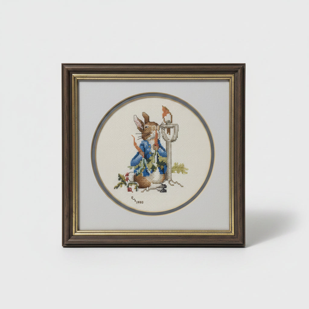 A framed circular art print featuring a whimsical illustration of a rabbit in a blue coat and a small figure with a hat, displayed on a wooden surface.