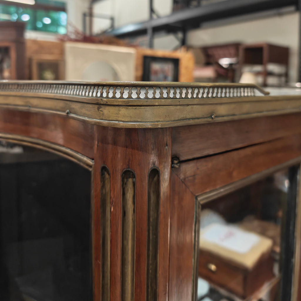 Close-up of a wooden mirror frame with a blurred indoor setting in the background