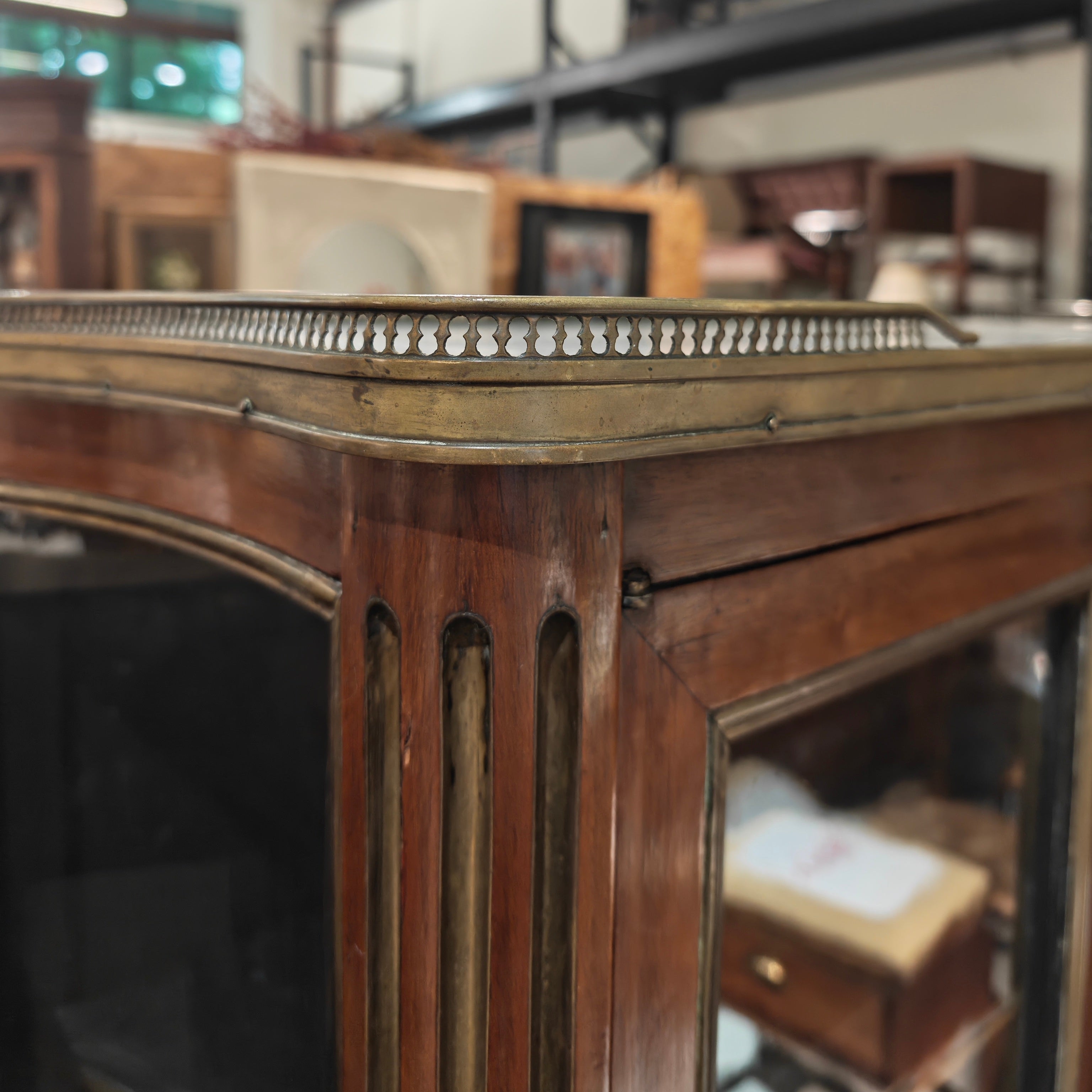 Close-up of a wooden mirror frame with a blurred indoor setting in the background