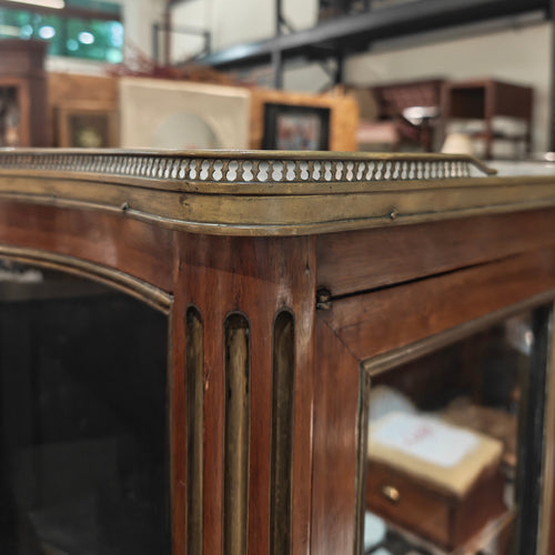 Close-up of a wooden mirror frame with a blurred indoor setting in the background