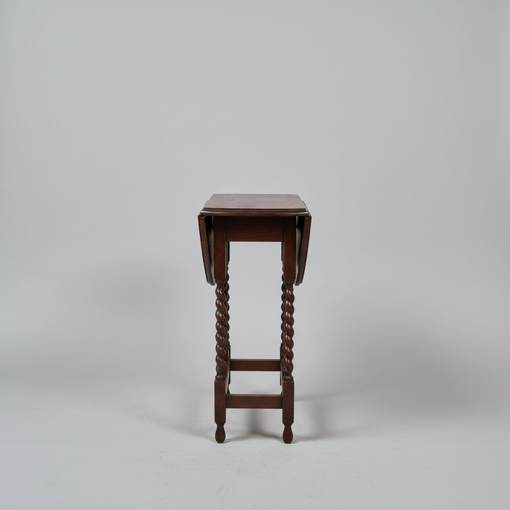 Wooden side table with twisted legs on a gray background