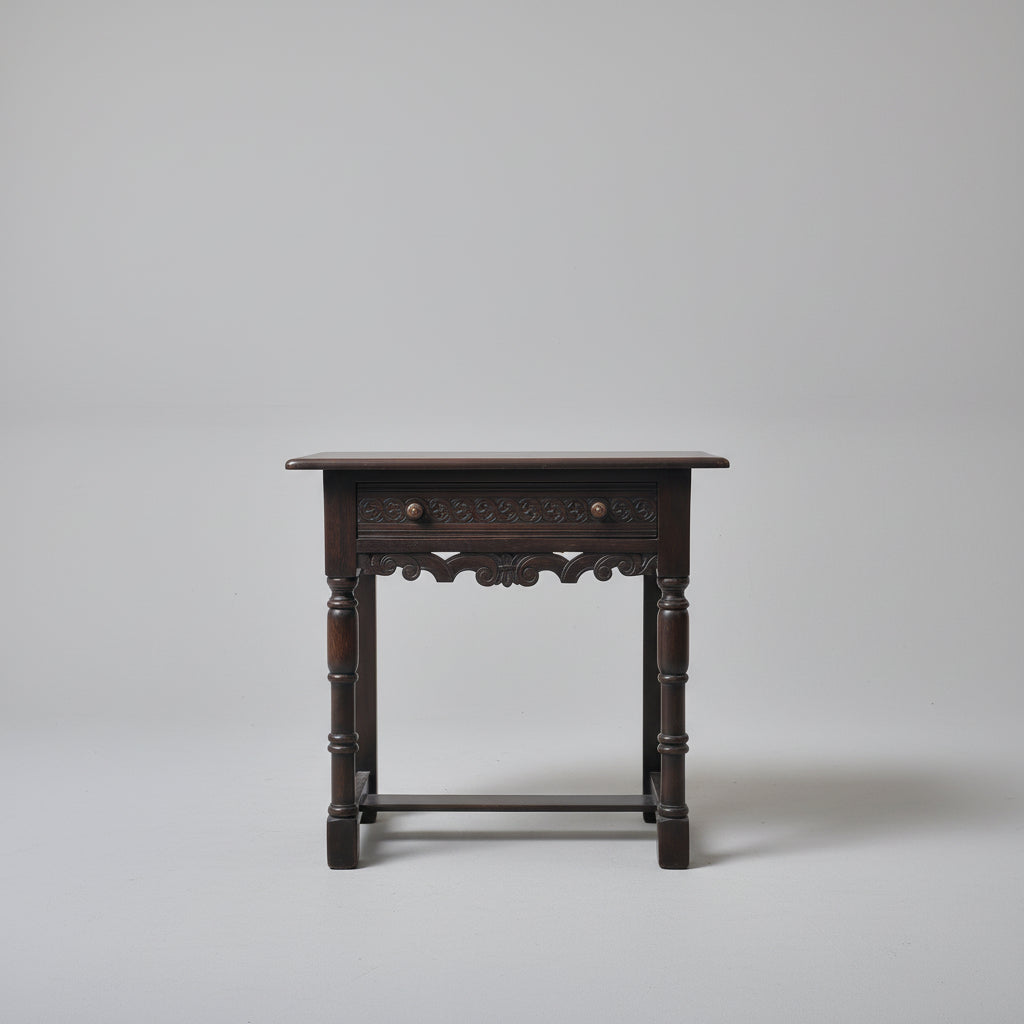 Wooden side table with decorative items on a red patterned rug against a white wall.