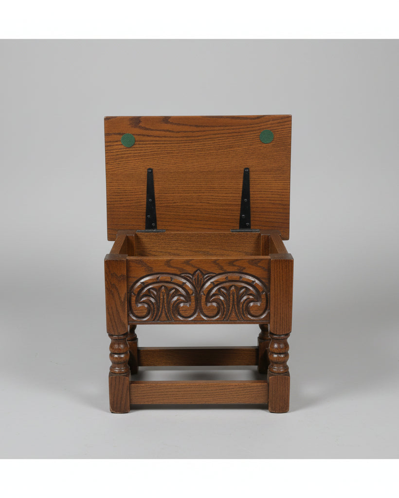 A dark brown wooden storage bench with carved floral details on the front and black metal H-bracket supports holding the open lid, set on a distressed concrete floor.