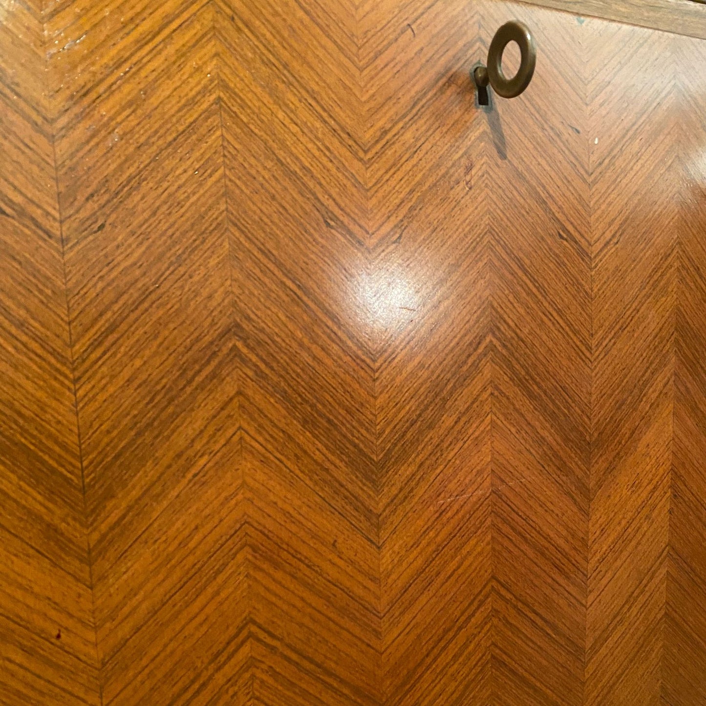 Wooden surface with a chevron pattern and a key on it