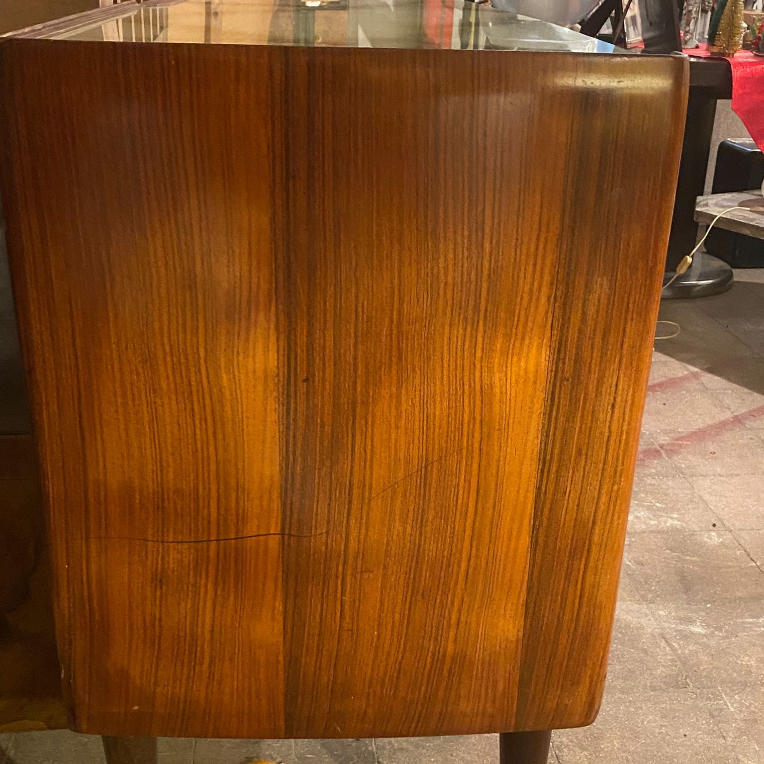 Wooden side table with a glossy finish on a tiled floor.