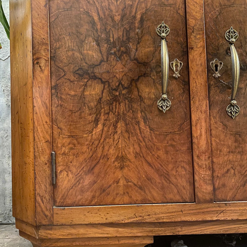 Wooden cabinet with decorative handles on a textured wall background