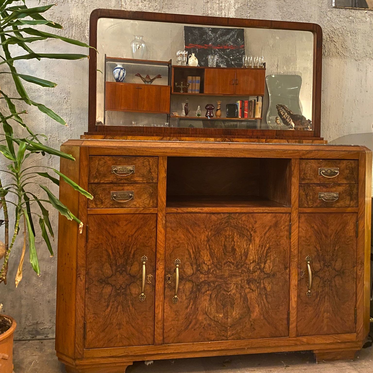 Vintage wooden sideboard with mirror against a textured wall.
