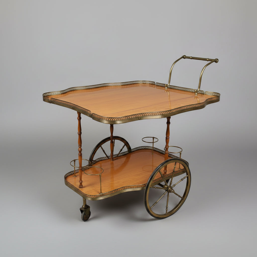 A vintage wooden serving cart or bar table with a light natural wood top, scalloped brass trim, and a lower brass tier, photographed in what appears to be a furniture store or warehouse.