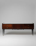 Wooden dresser with a dark finish in a room with sunlight streaming through a window.